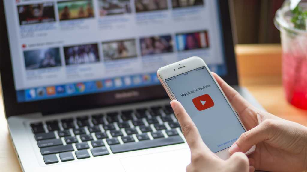 Youtube: Smartphone mit Youtube-Logo und im Hintergrund Youtube auf einem Laptop